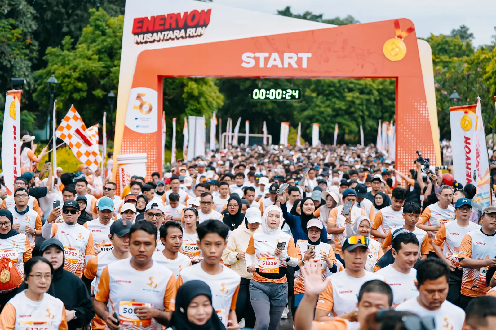 Pelari bersiap di bawah gerbang start Enervon Nusantara Run