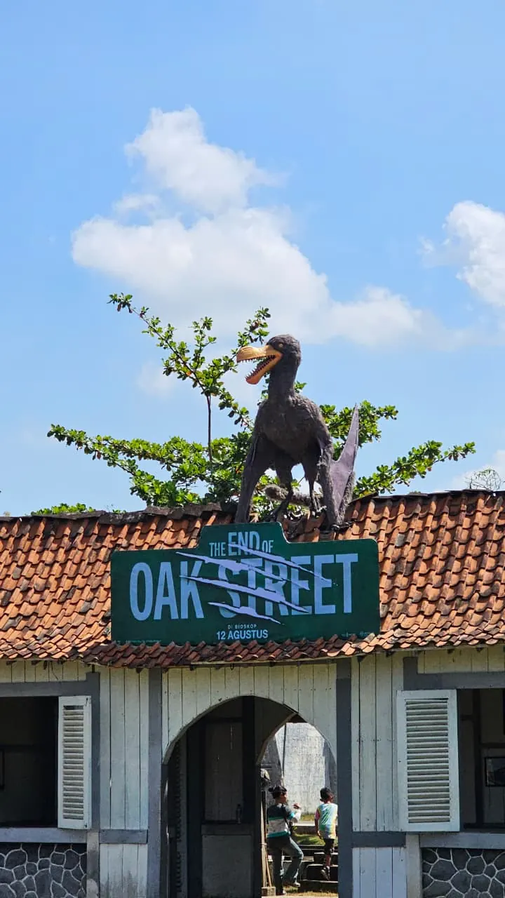 Papan nama Oak Street dan figur makhluk di atap instalasi